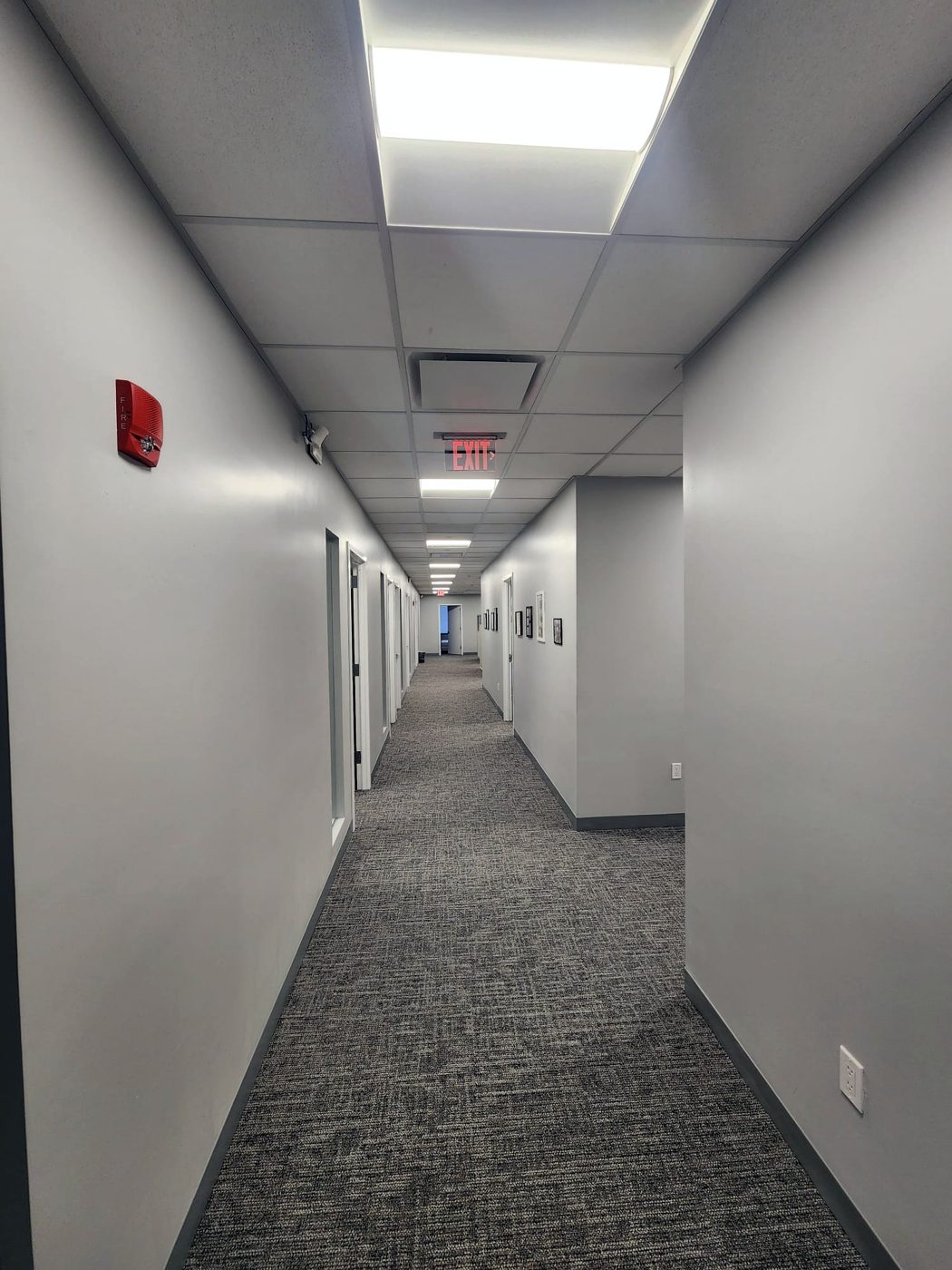 Finished office corridor with fire alarm device and exit signage