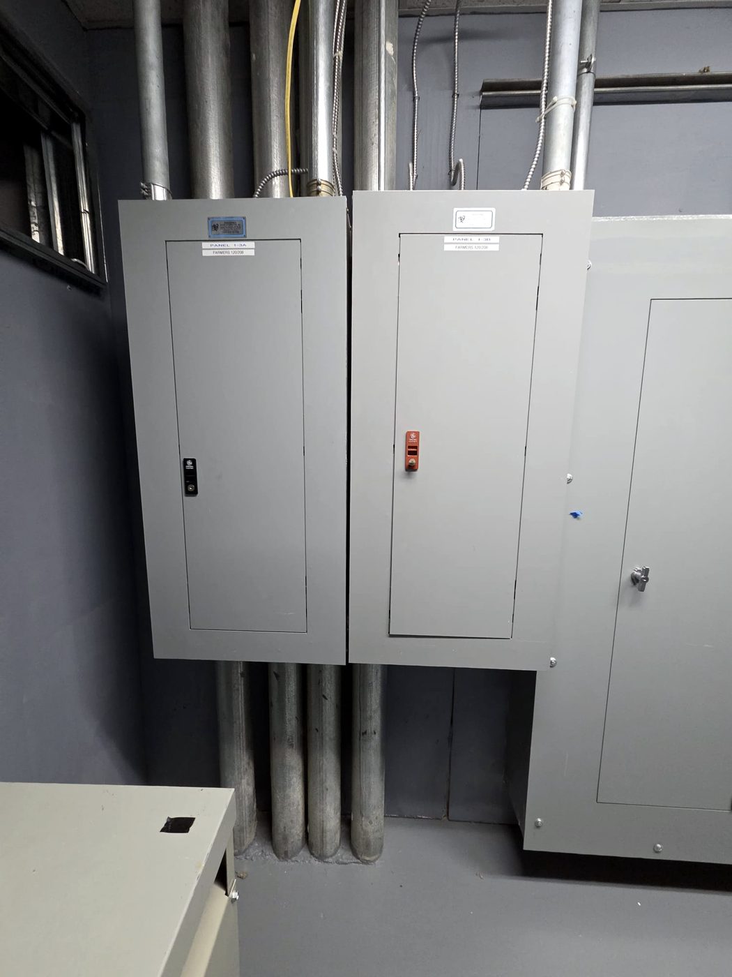 Gray distribution panels on a commercial electrical room wall