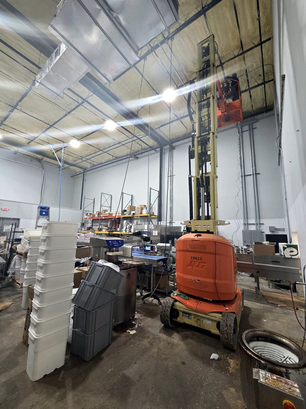Food plant with tanks and a lift used for overhead electrical work