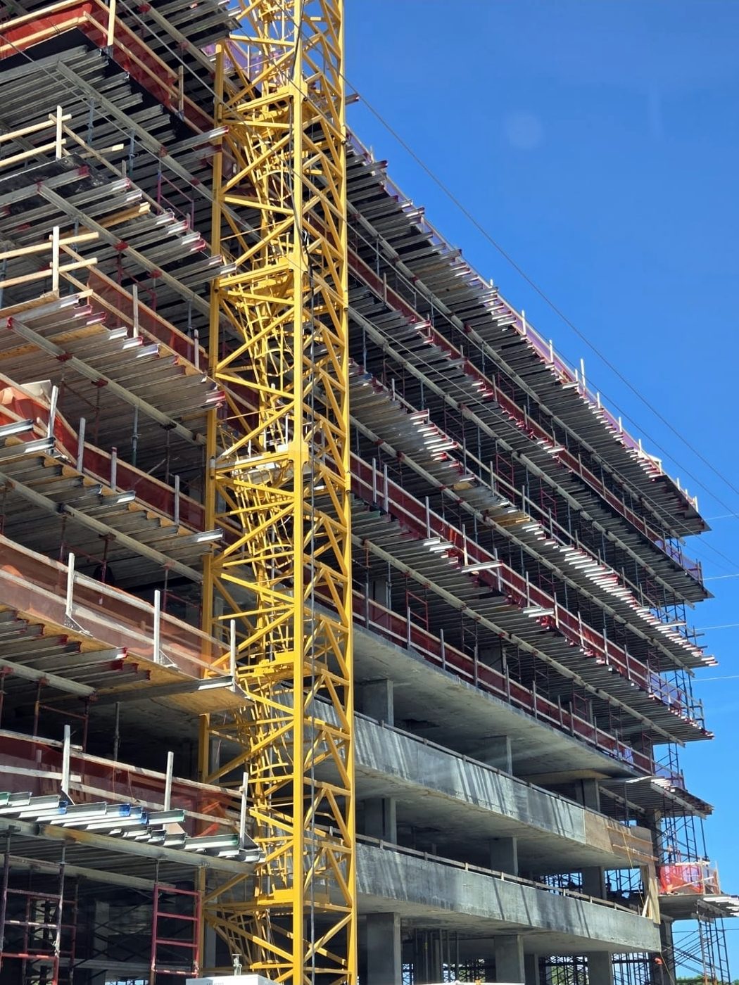 Multi-story building under construction with a tower crane